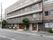 ４階建ての鉄筋コンクリートの建物である。道路に面しており、植え込みがある。１階には、訪問介護事業所が併設されている。