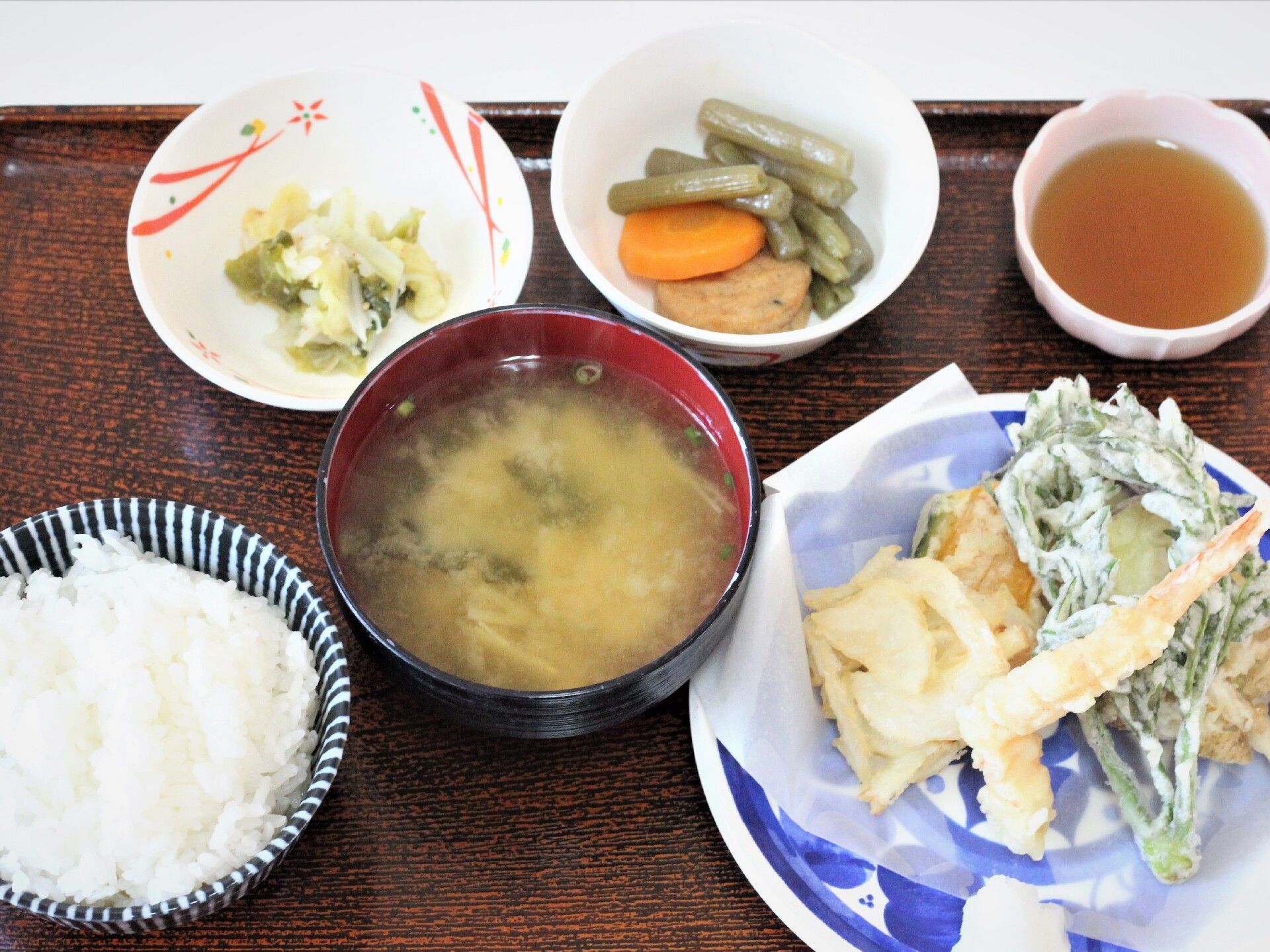ご飯と味噌汁、天ぷらと野菜の煮物がセットになった食事