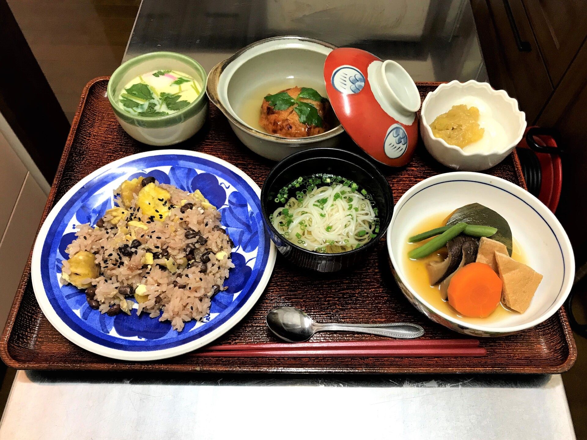 栗ご飯と汁物、野菜の煮物や茶碗などの小鉢が付いた食事