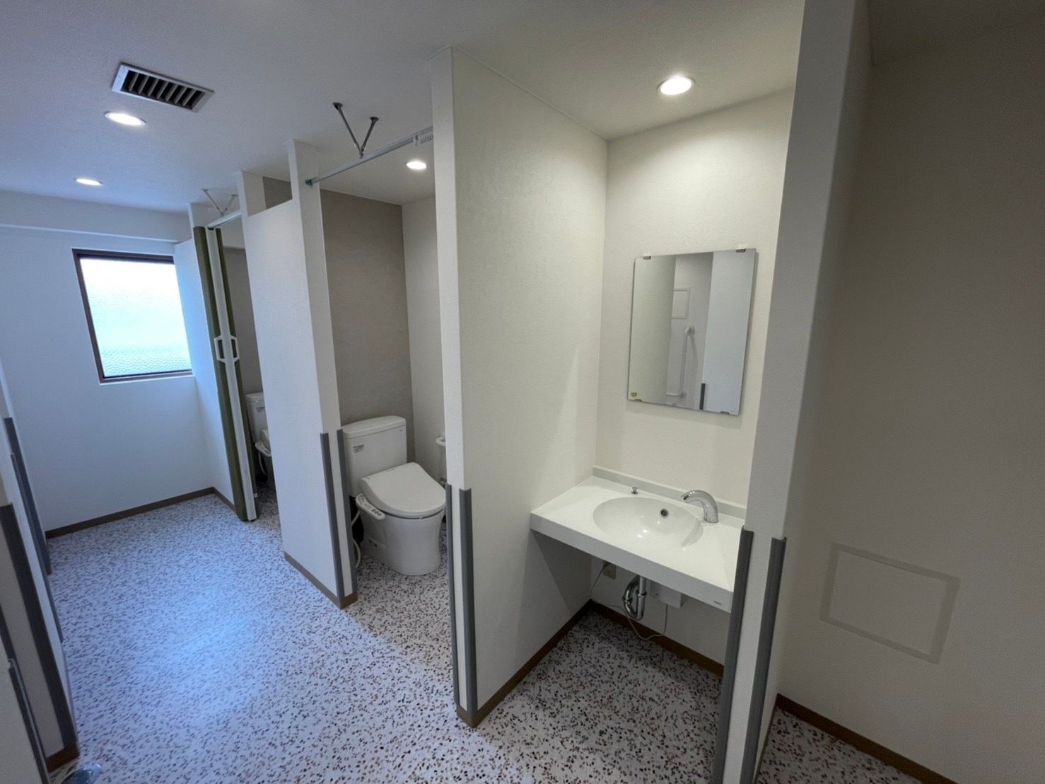 手前には車いす対応の洗面所があり、奥にはトイレが二つ設置されている。通路も広く、角にはクッション材が使用されている。