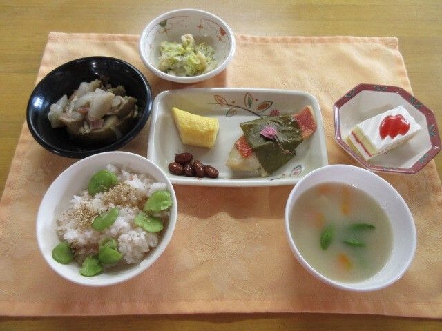 車いすに乗った女性を押す家族の男性とそこに寄り添う介護スタッフの様子