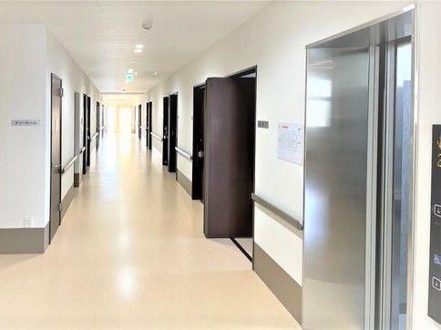 手すりと個室のドアが写っている廊下の様子。施設内の共有スペースの写真