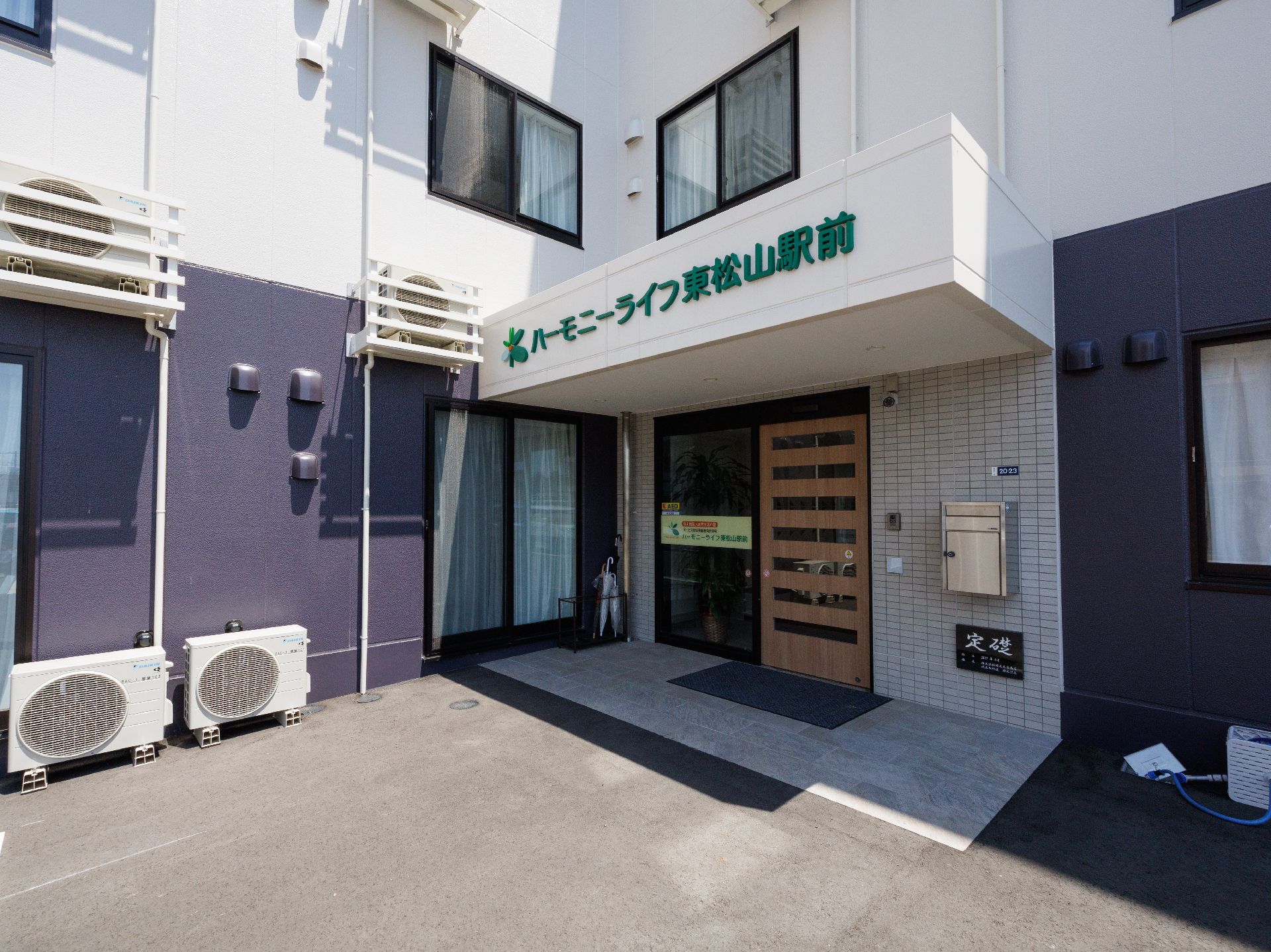 なにかに笑顔で手を振っている女性とその人の方を持ち同じ方向に笑顔を見せているスタッフ