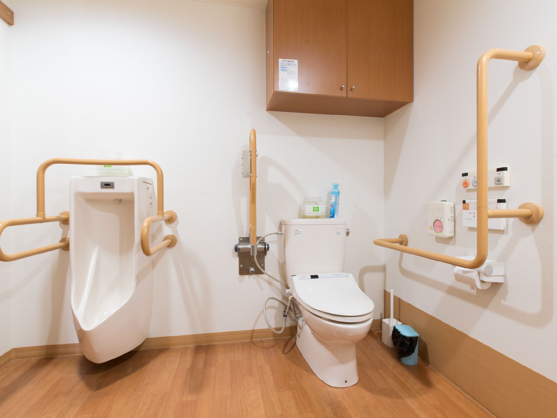 暖房便座付きトイレと、男性用便器が備え付けられている。呼び出しボタンがある。収納棚が上部に取り付けられている。