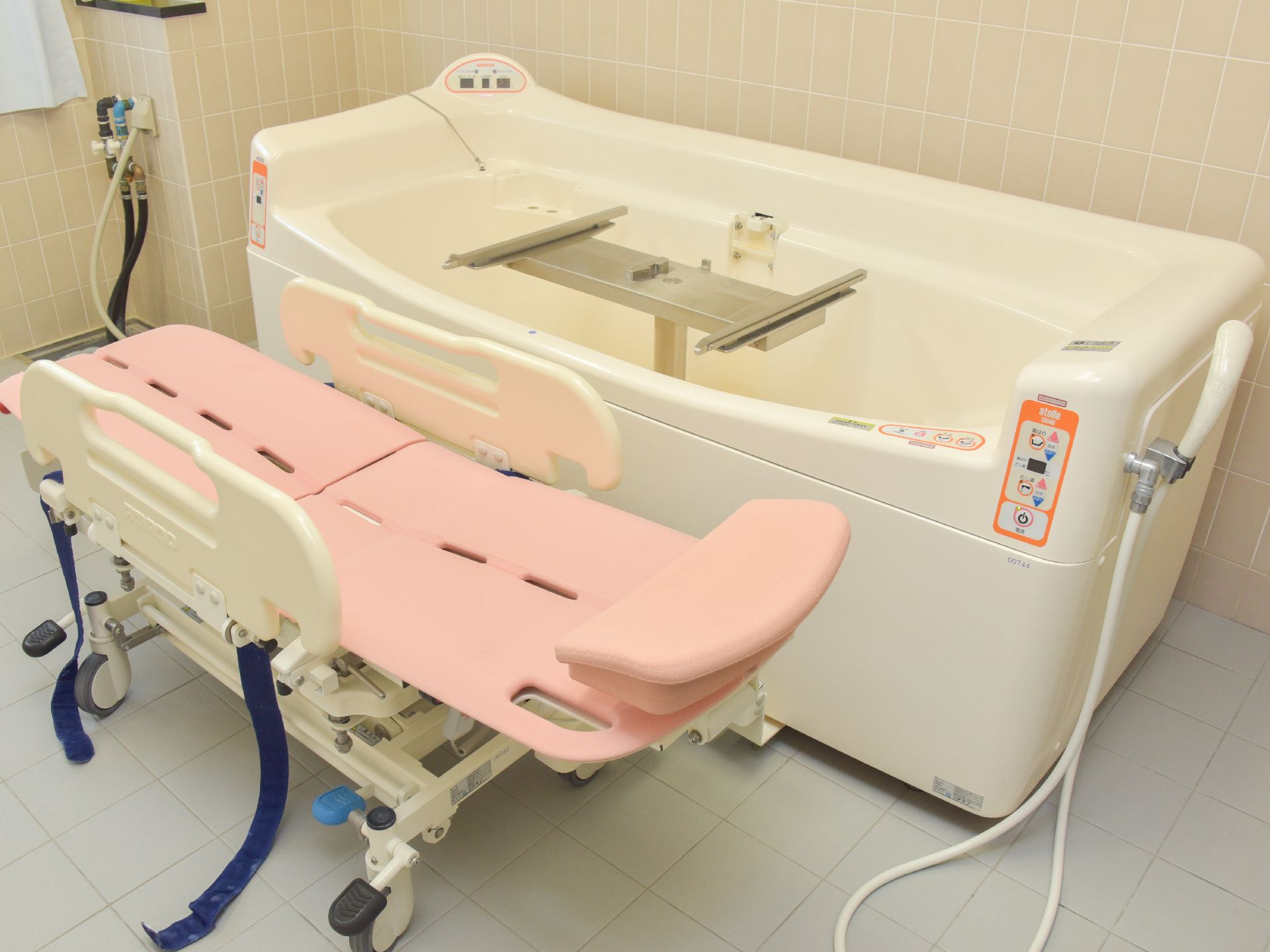 壁面、床がタイルでできているお風呂場である。体の自由が利かない方でも座ったままの状態でお風呂を楽しむことができる介助バスが設置されている。