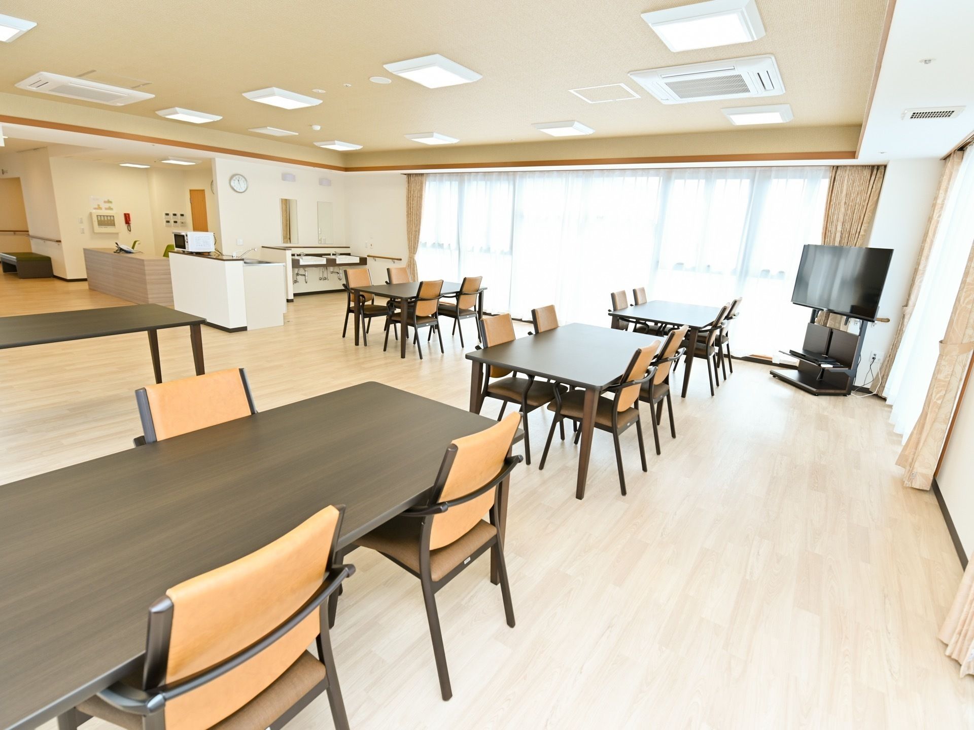 木製のダイニングテーブルがゆとりを持たせた配置で置かれた食堂。