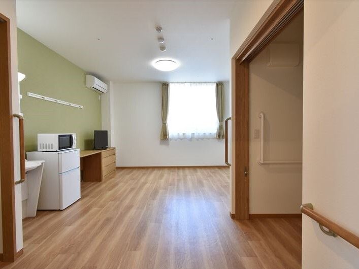 エアコンや照明が付いたグリーンの部屋には冷蔵庫やテレビ、電子レンジが置かれ、トイレや洗面所もある。