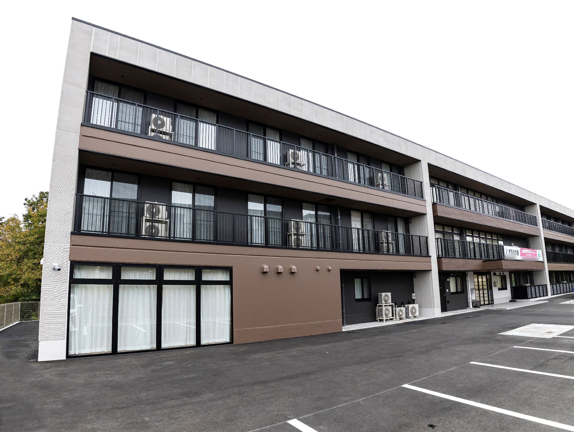 駐車場の出入り口から見た、斜め前から見た施設全体の外観