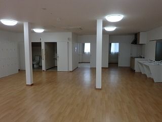 フローリングのフロアの共有スペース。左奥にはトイレが二つあり、右側には車いす対応の洗面所もある。
