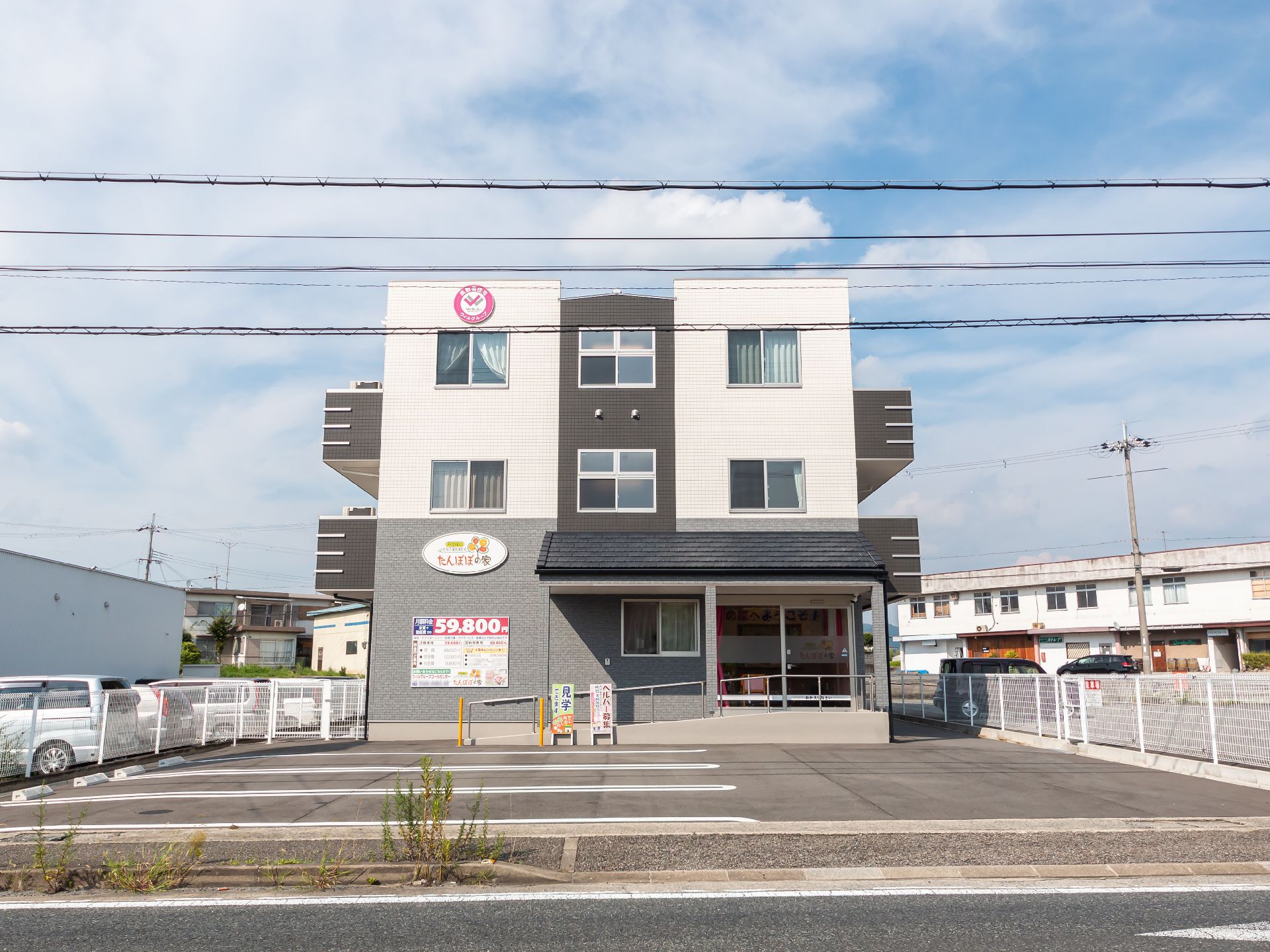 アスファルト沿いに立地している白と黒の外観の建物