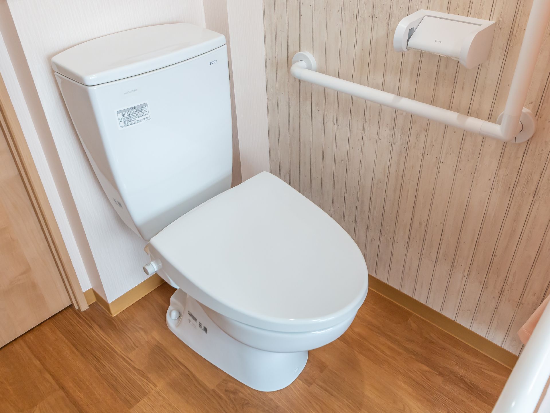 部屋の一角に設けられた蓋が閉まった洋式便器