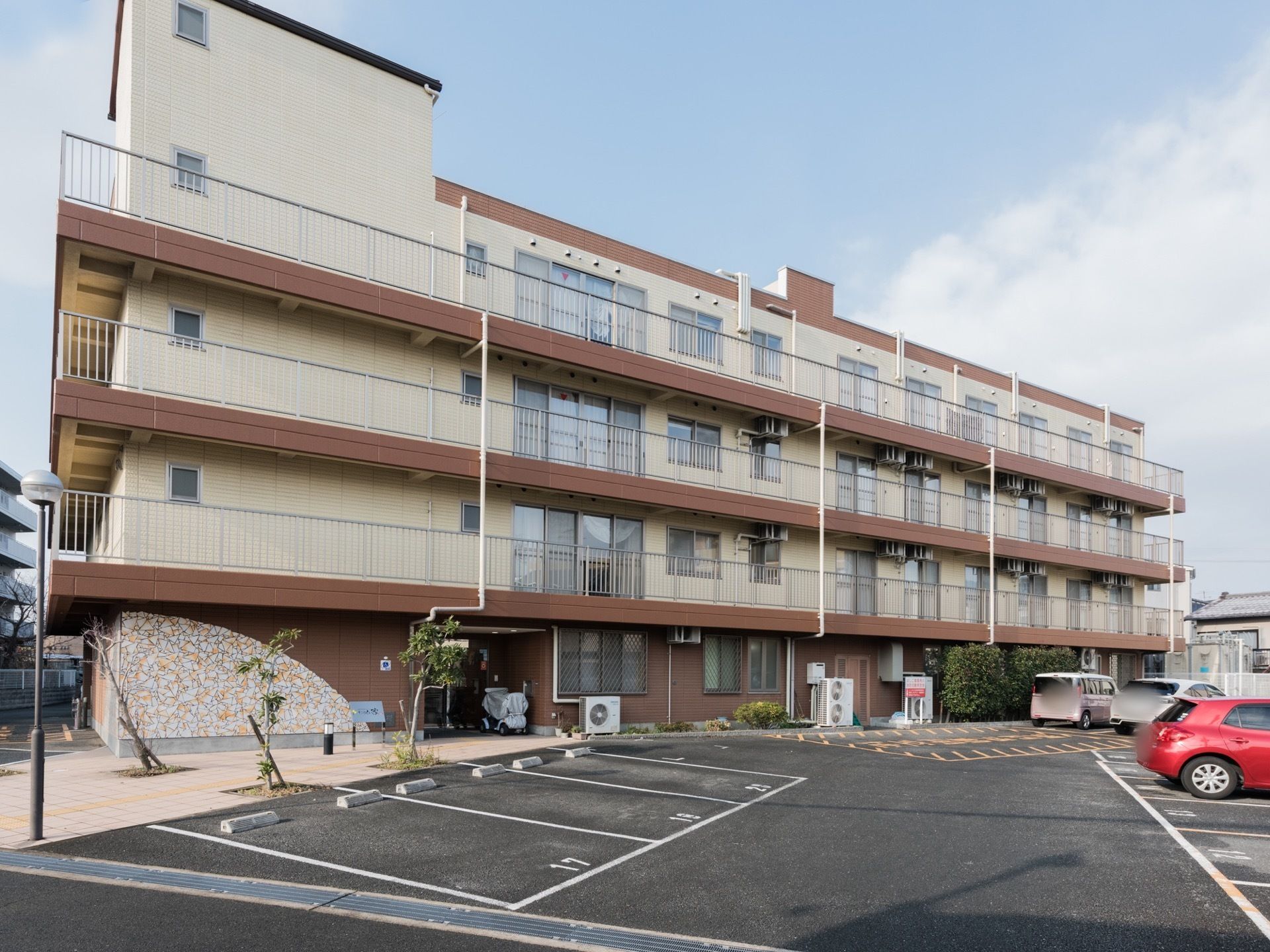 駐車場も設けられた広い敷地の4階建て施設になっている。各部屋には窓が設置されていて、ベランダもあるので景色、採光と恵まれている。