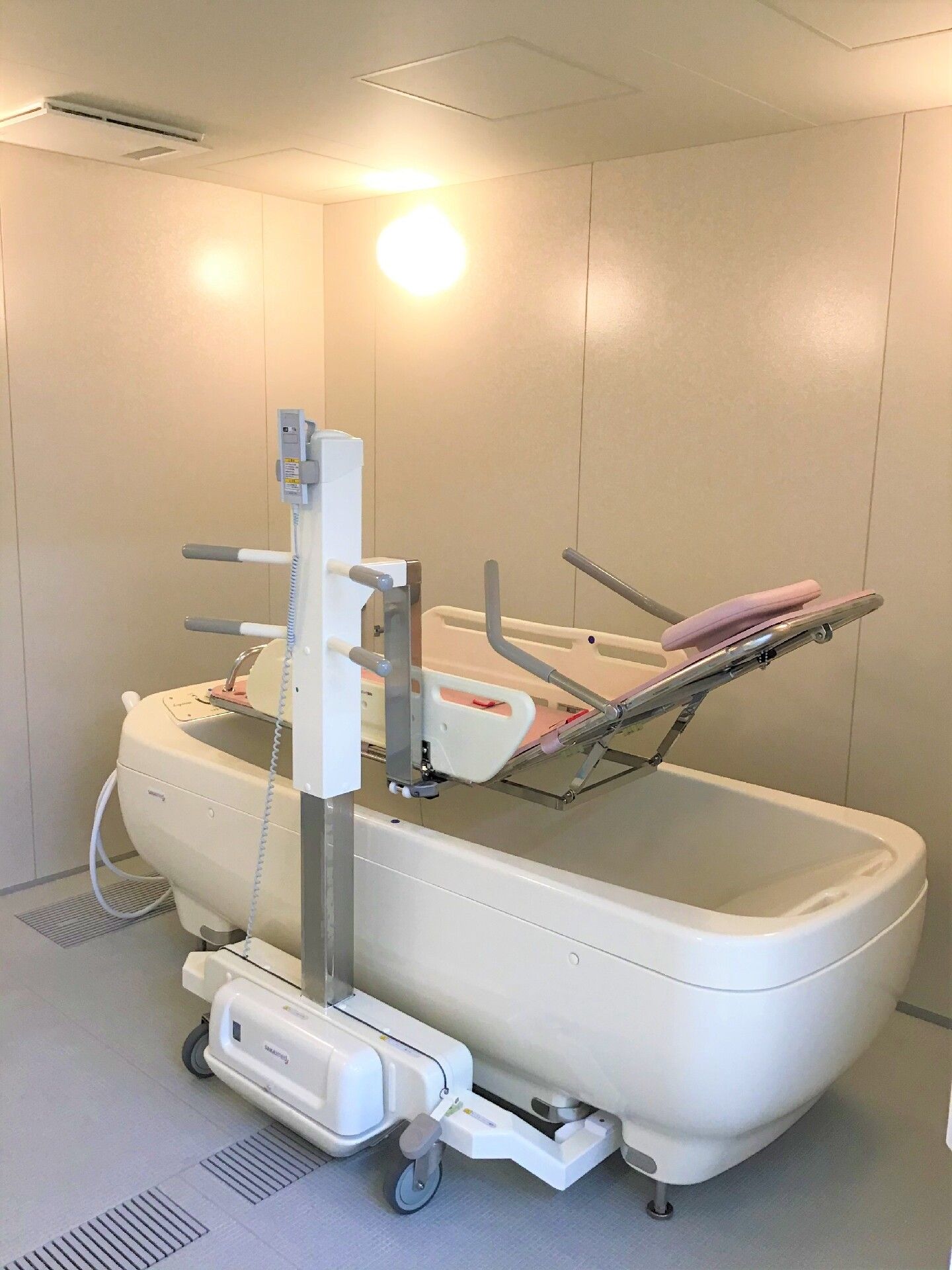 寝台浴が設置された浴室にはシャワーや窓がなく、シンプルなデザイン。円形のライトが設置されている。