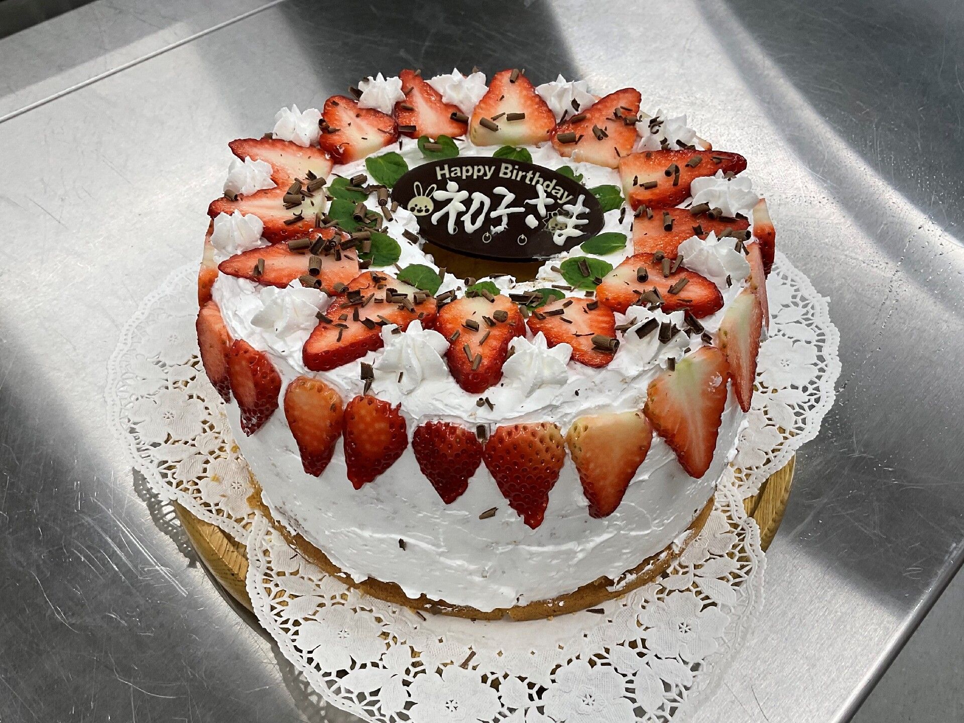 いちごと生クリームで飾られた大きなケーキは迫力満点。「初子さま」と書かれたチョコレートプレートが飾られている。