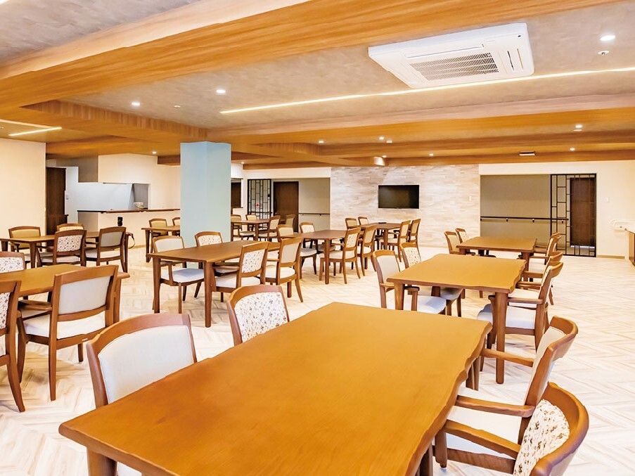 4人掛けの木製のダイニングテーブルセットが複数置かれている食堂の奥にはキッチンも設置されている。