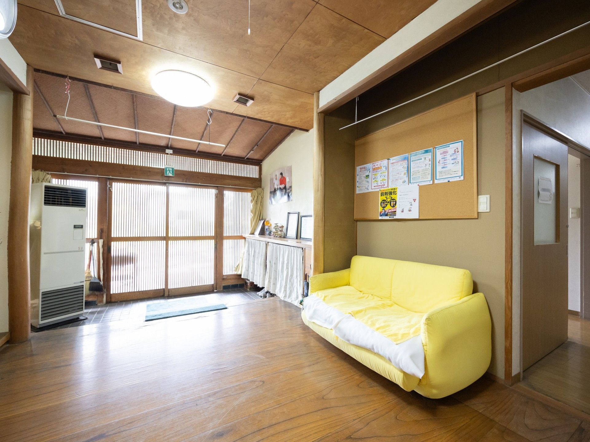 高齢者の方にタオルをかけてマッサージしているスタッフと振り返りながら会話する女性の様子