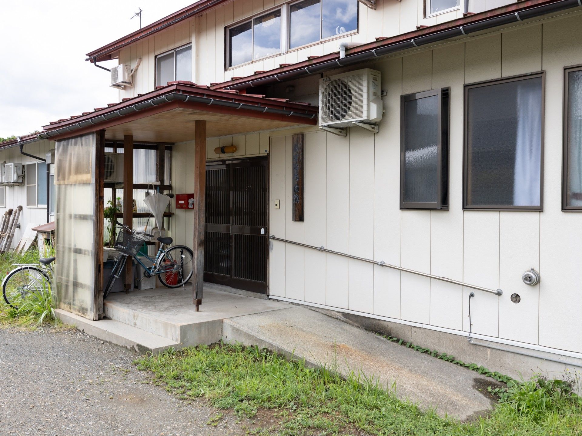 なにかを指さして笑顔で話している車いすの女性とそれを押している介護スタッフの様子