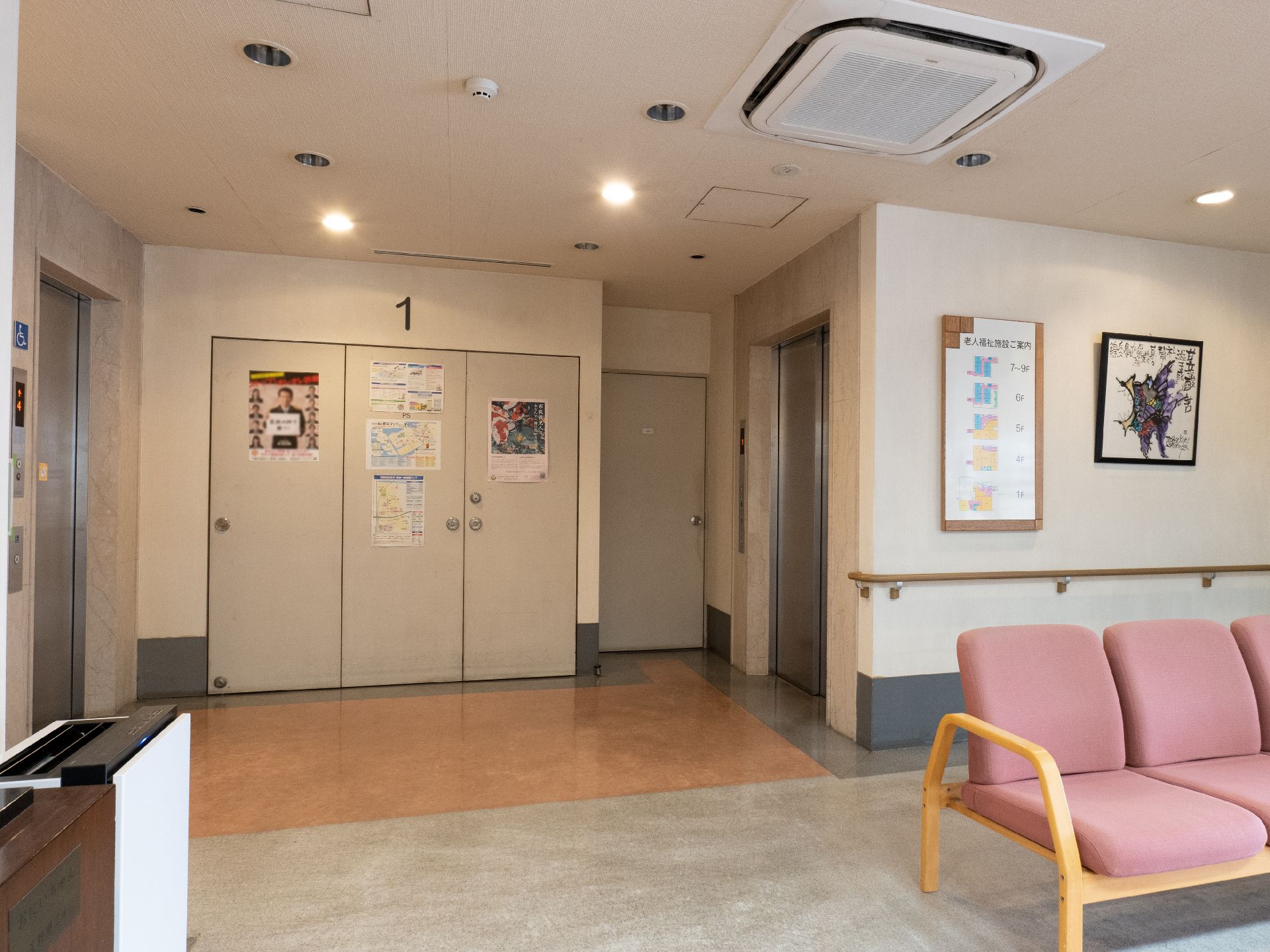 園児たちと高齢女性たちが一緒に新聞紙の敷かれたテーブルを囲んでいる。園児たちは作成した紙皿の面をかぶっている。
