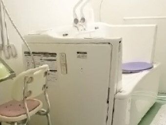 白い機械浴が設置された浴室にはシャワーやシャワーチェアも完備されている。浴槽をまたぐことが難しい方もご入浴できる機械浴。