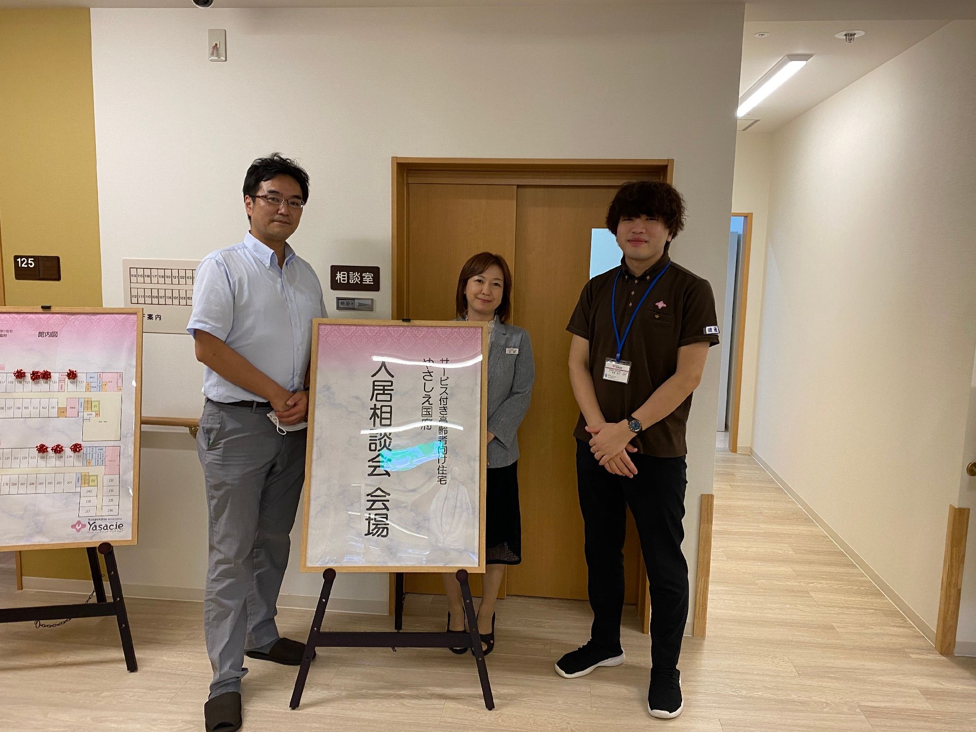 高齢者と一緒にカルテのようなものを眺めている施設内スタッフとの2ショット