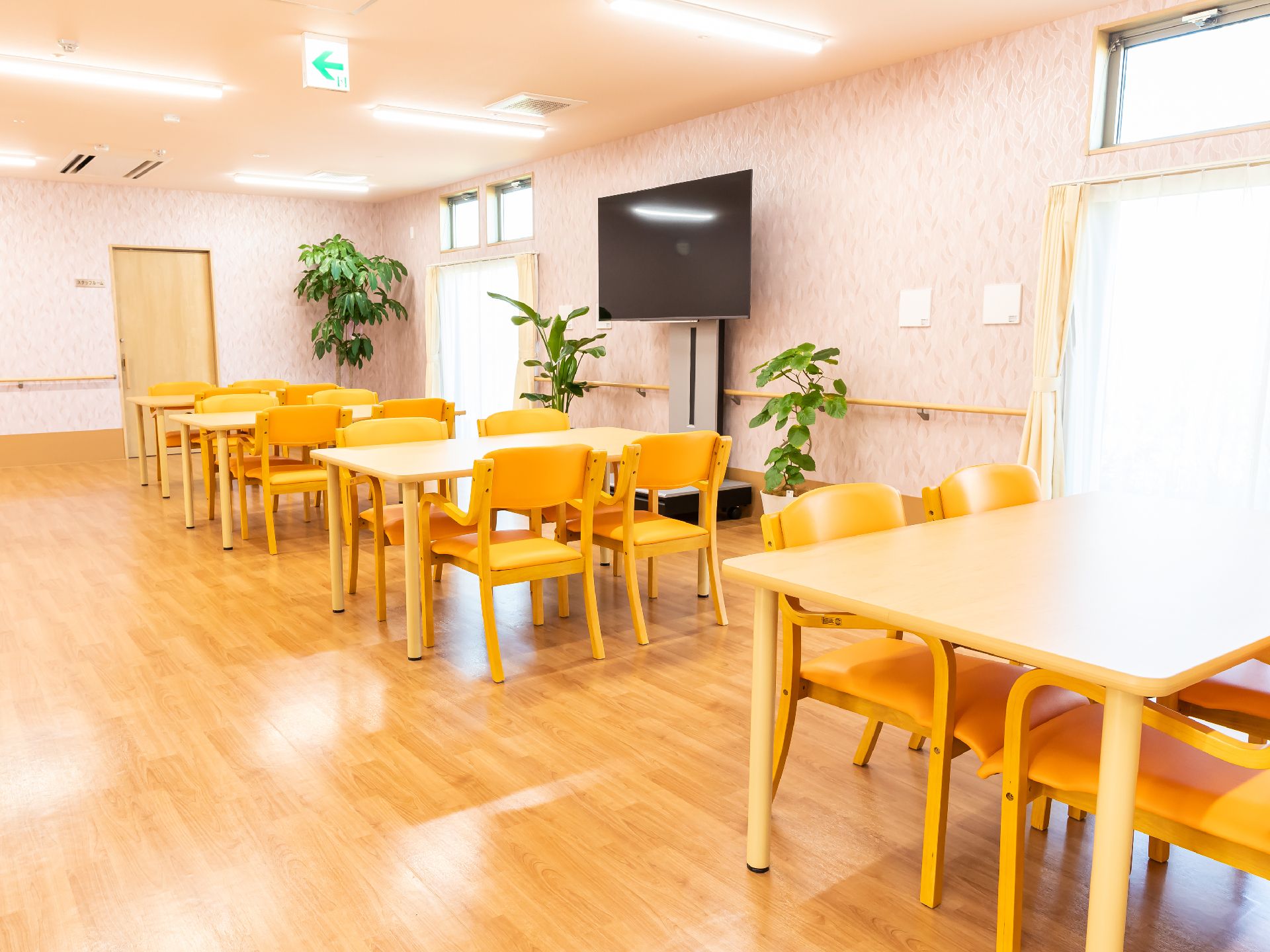 大きなテーブルを挟んで椅子が複数設置されている共有スペース