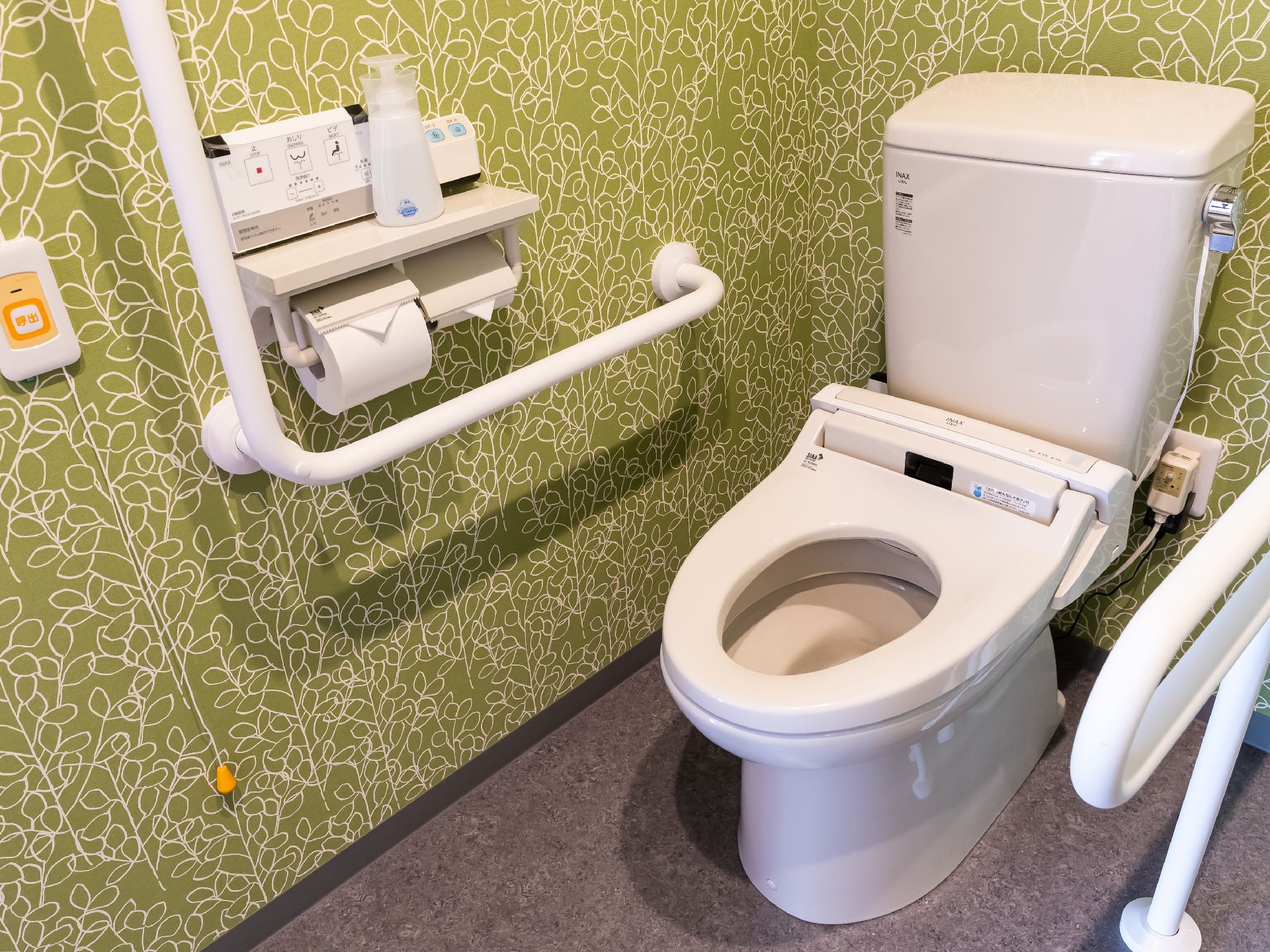 大きなL型手すりが取り付けられ、段差もすべて解消されているトイレ