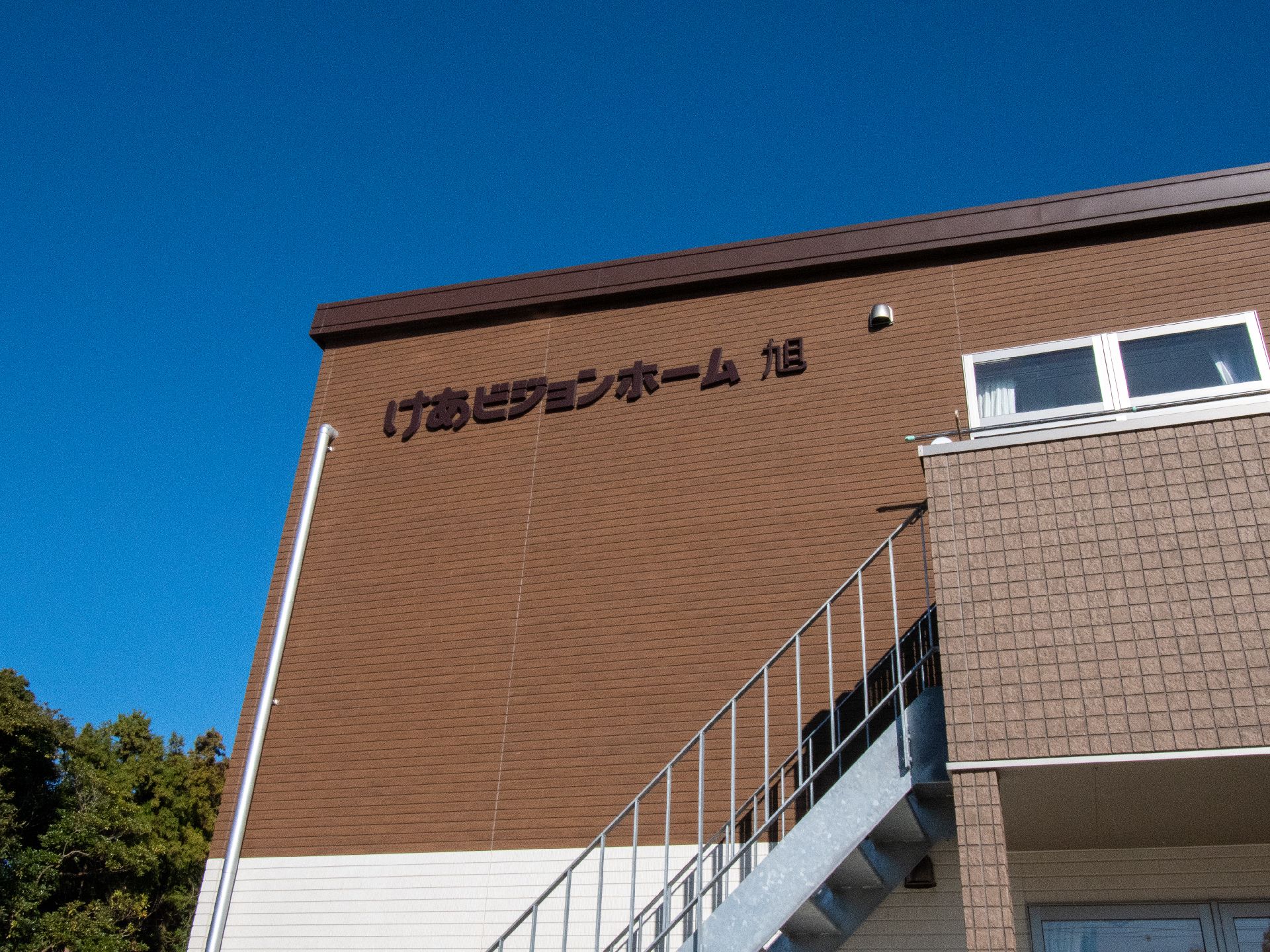 茶色い外壁に施設名が書かれている外観