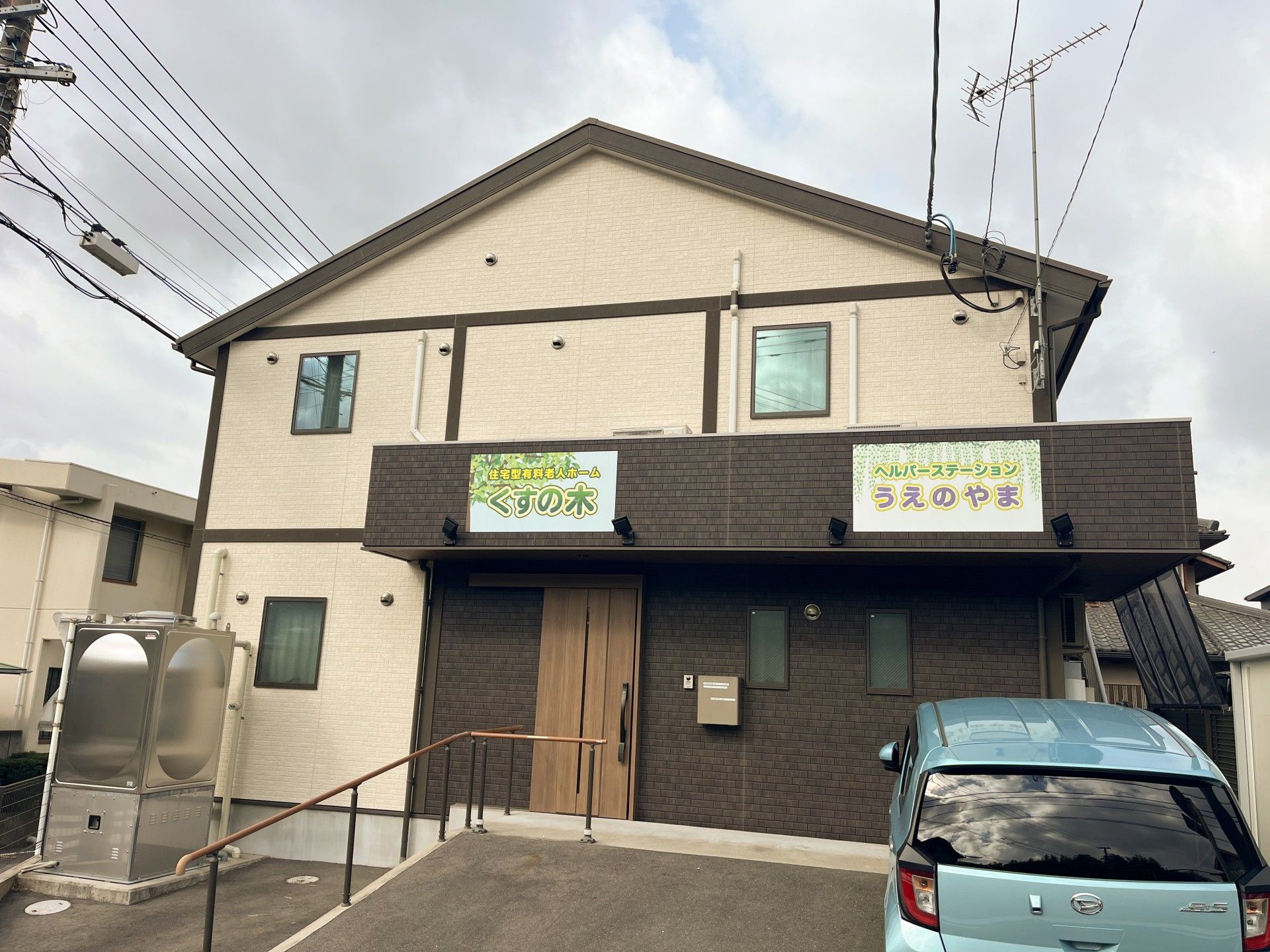なにかを指さして笑顔で話している車いすの女性とそれを押している介護スタッフの様子