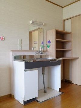 フッとレス仕様の洗面台と物入が置いてある施設内の居室の様子