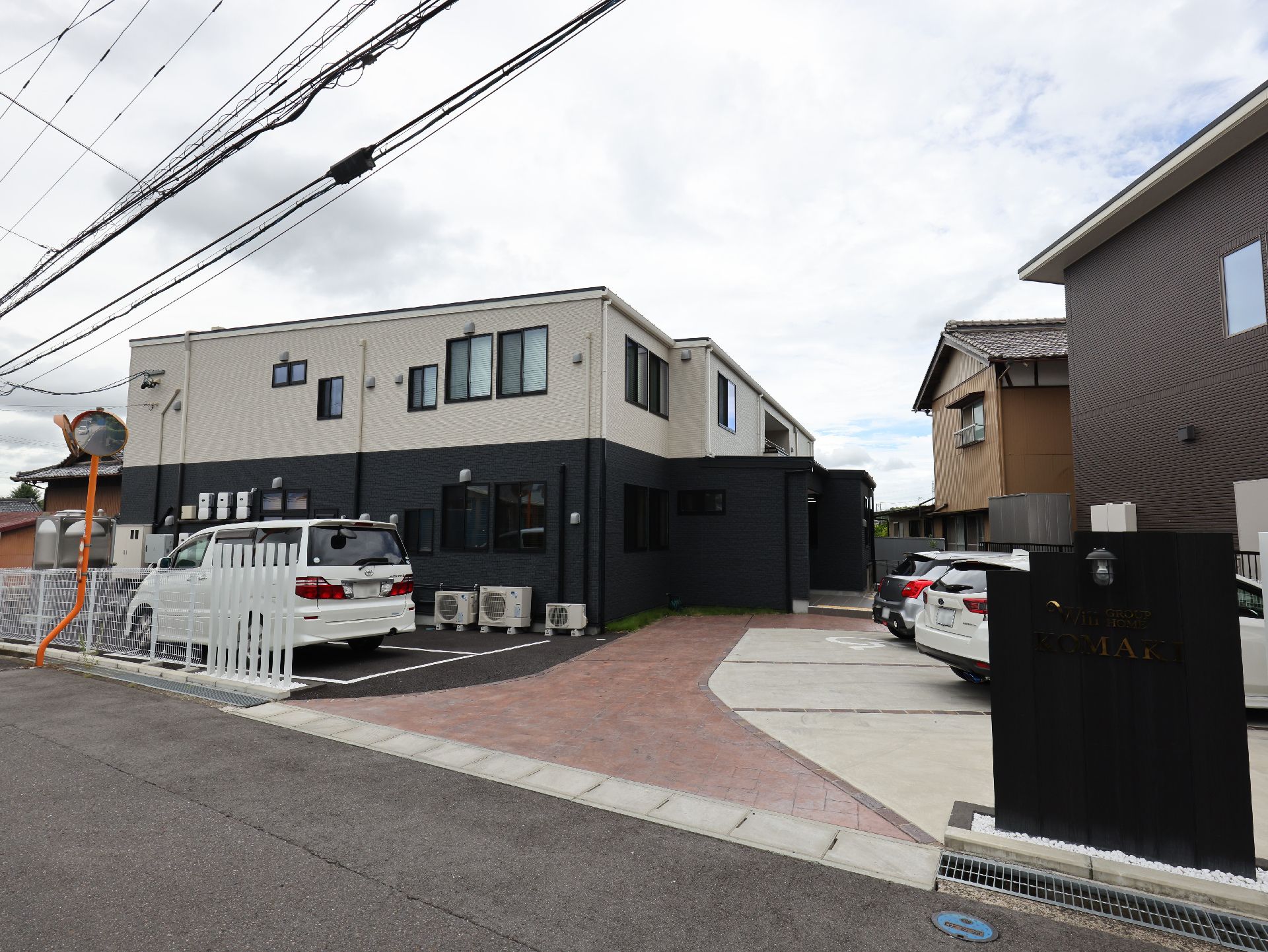 １階部が黒で２階部が白の２階建ての建物