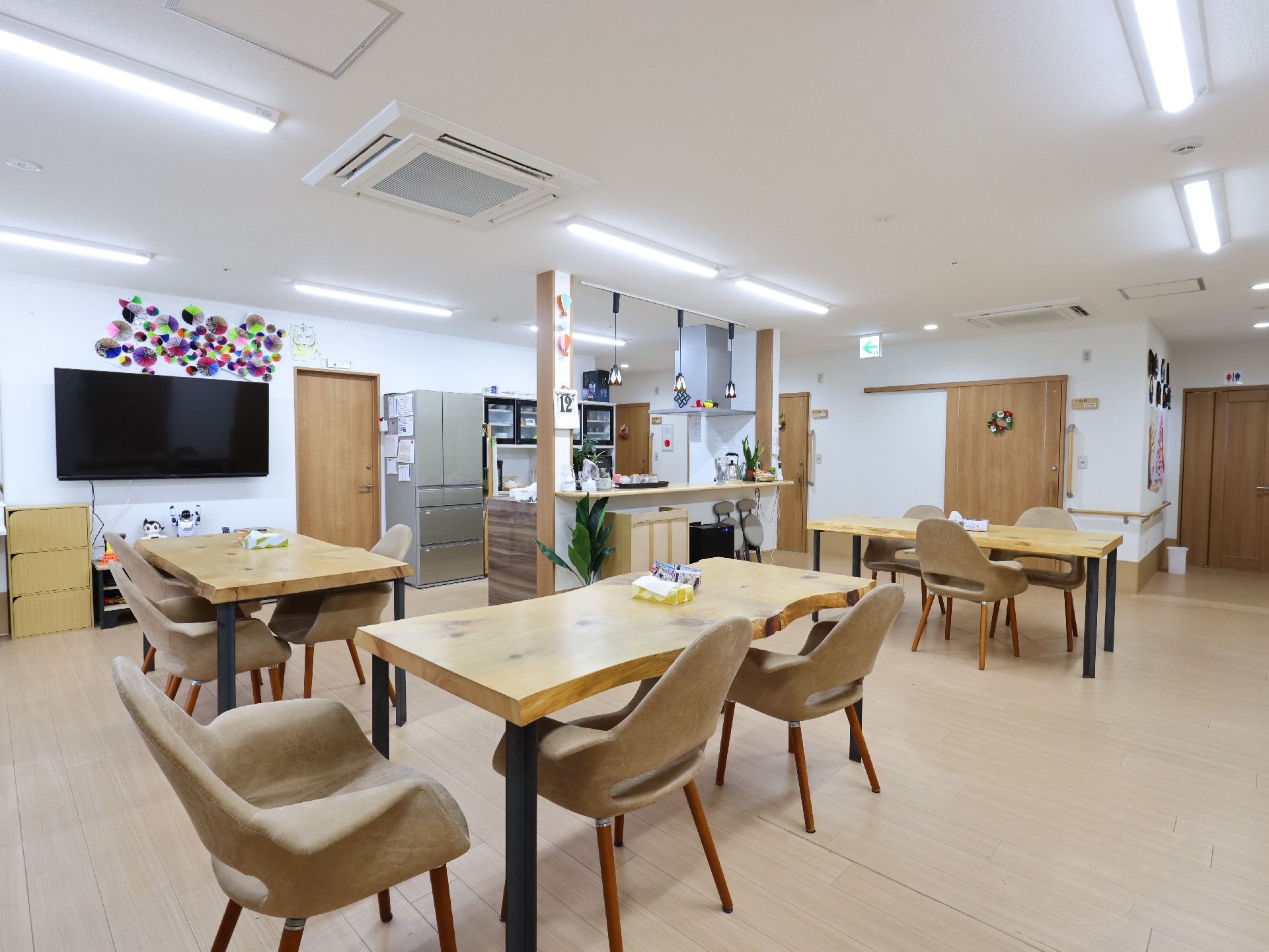 木製の机が並んだ白い壁の広間