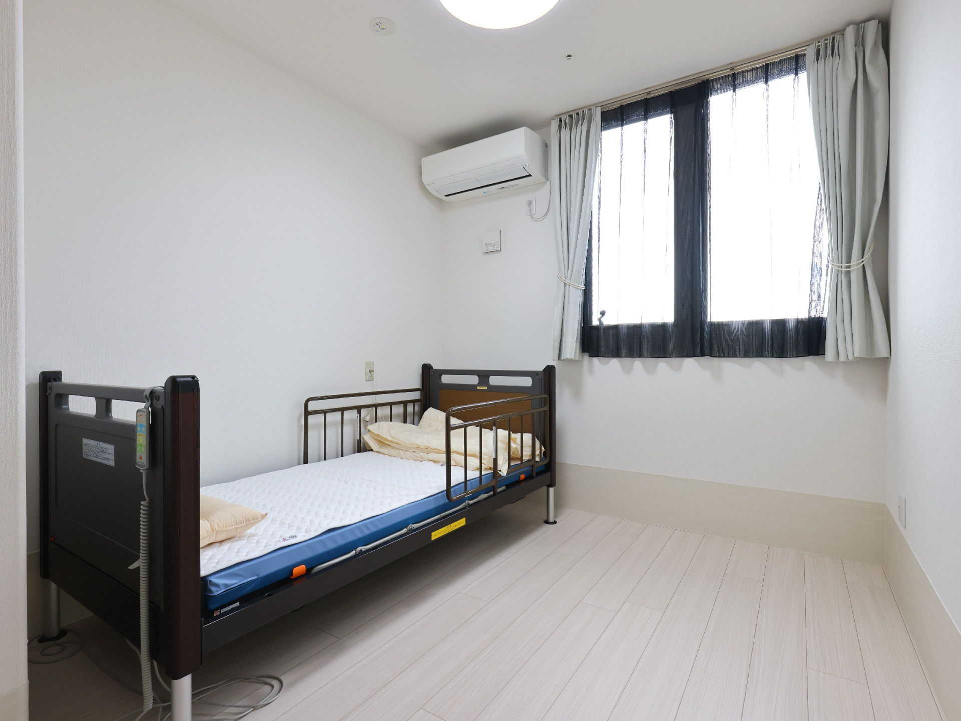 ベッドの置かれた白い壁の部屋