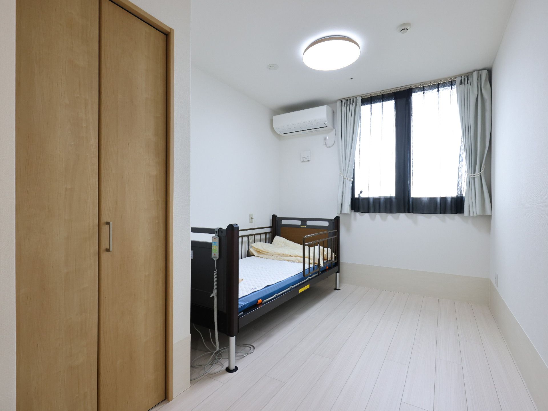 ベッドの置かれた白い壁の部屋