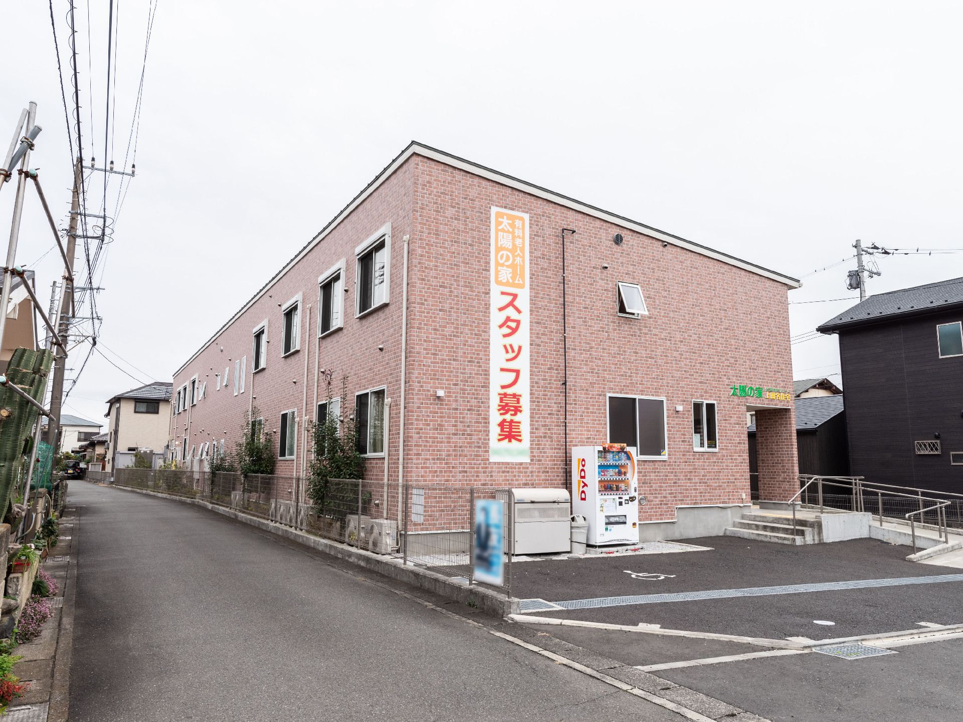 施設の名称が記載されている旗とオブジェクトが設置されている玄関