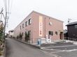 施設の名称が記載されている旗とオブジェクトが設置されている玄関