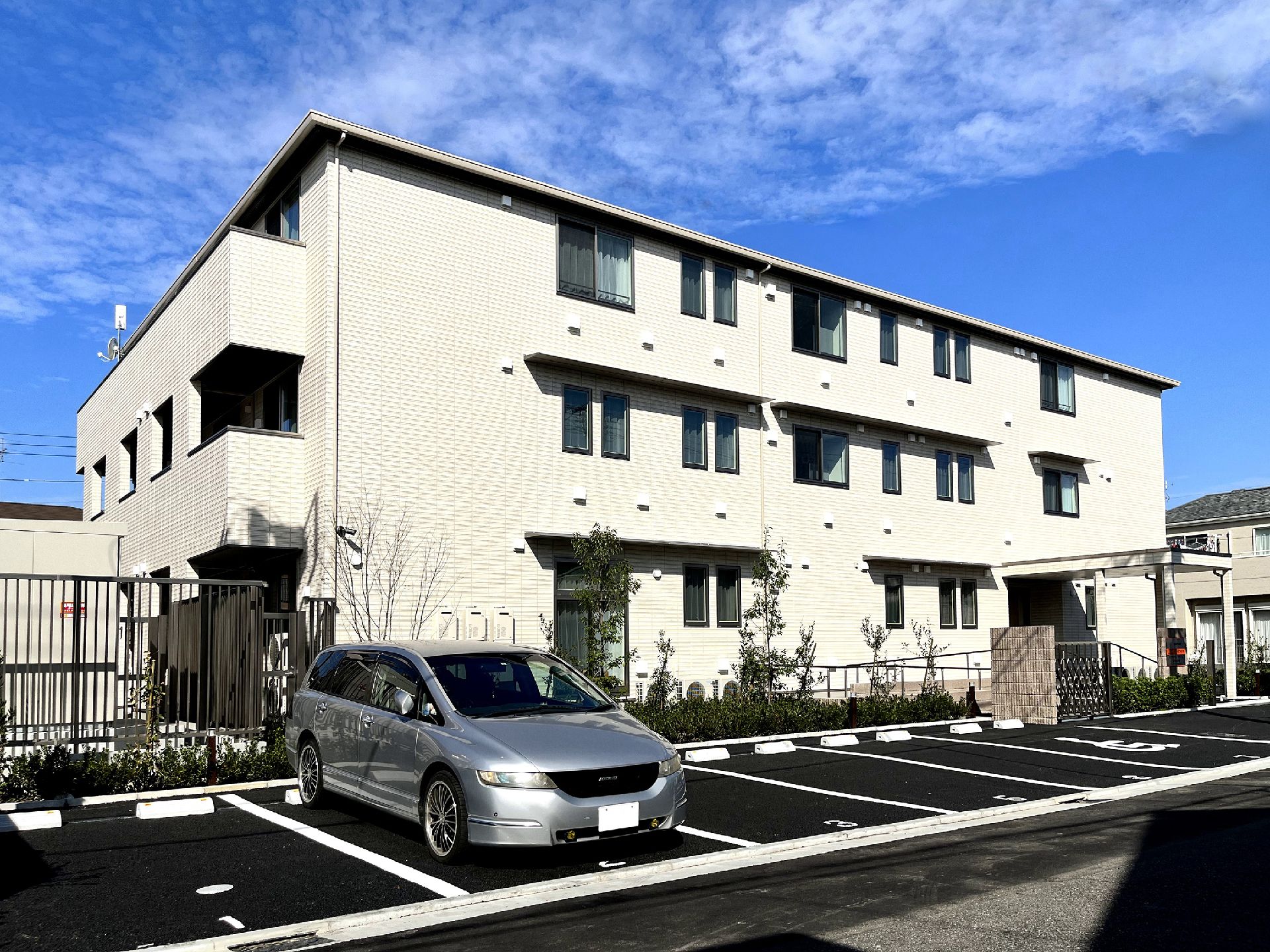 なにかを見て笑顔で手をたたいている高齢女性とスタッフの様子。施設での一場面の写真