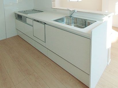 白を基調とした広いキッチンにはIHクッキングヒーターや食器洗浄乾燥機が付き、流しはステンレス製。調理器具などはない。