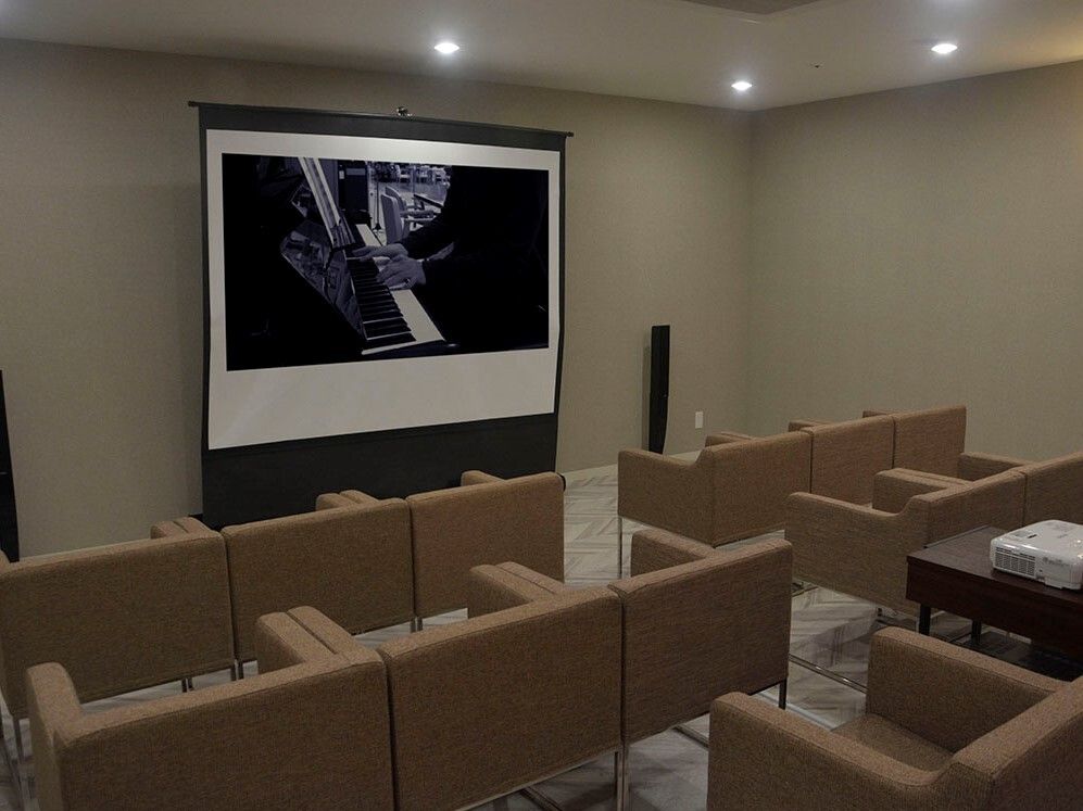 テーブルの上にはt難バリンやマイクが置かれ、部屋の中にはカラオケセットがあり、ソファも設置されている。