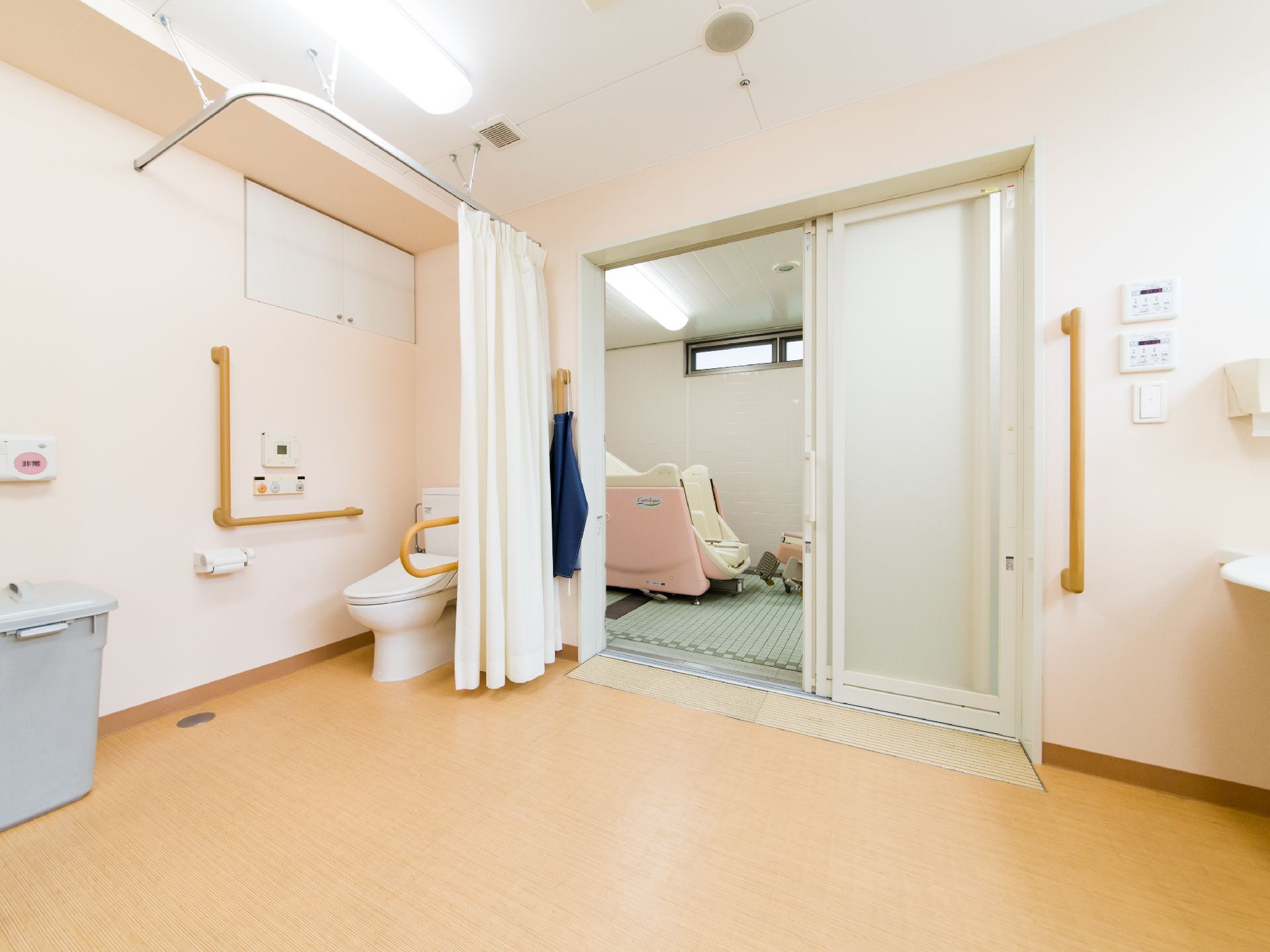介助用入浴設備は、特別浴室の一番奥の部屋に設置されている。近くに、複数の手すりが取り付けられた洋式トイレが設置されている。