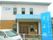 2階建ての建物の玄関には屋根が付き、敷地内には車が止められている。周りには白いフェンスがあり、ホーム名が書かれた看板がある。