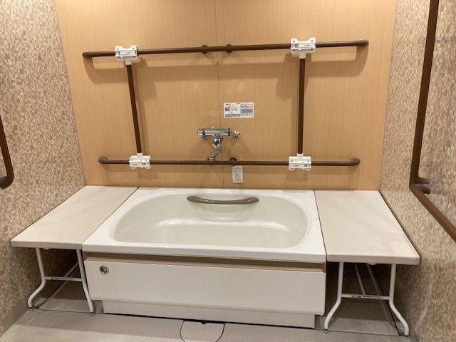 高齢者と一緒にカルテのようなものを眺めている施設内スタッフとの2ショット