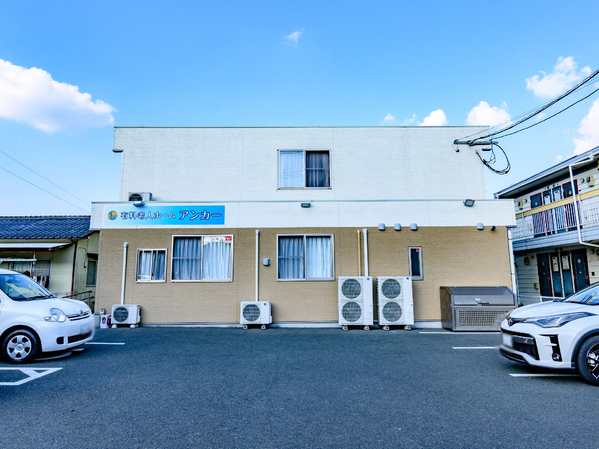 青色の看板が設置された介護施設の外観