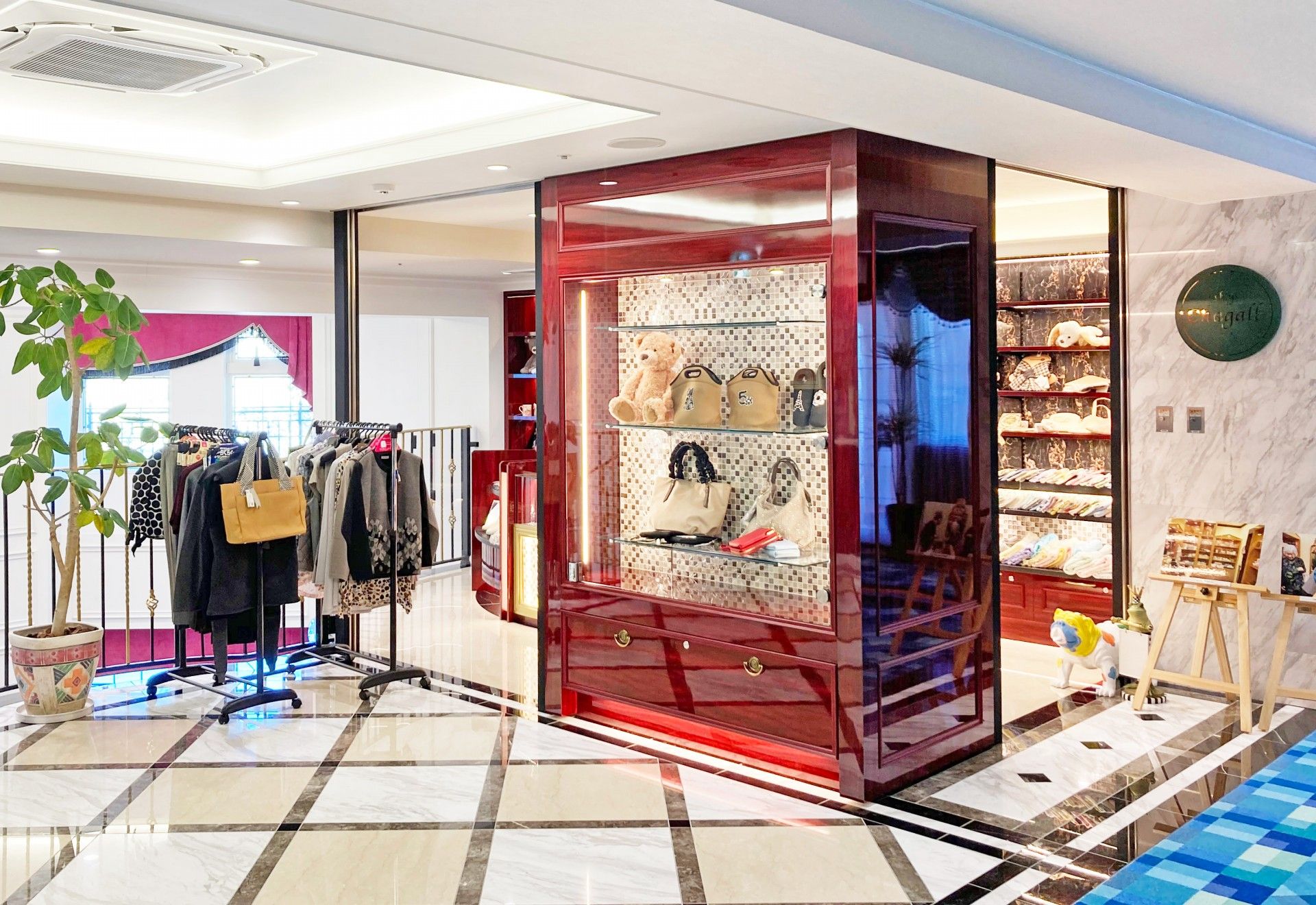 服やスカーフなどがかけられた棚の横にははラスのショーケースがあり、アクセサリーが並んでいる。