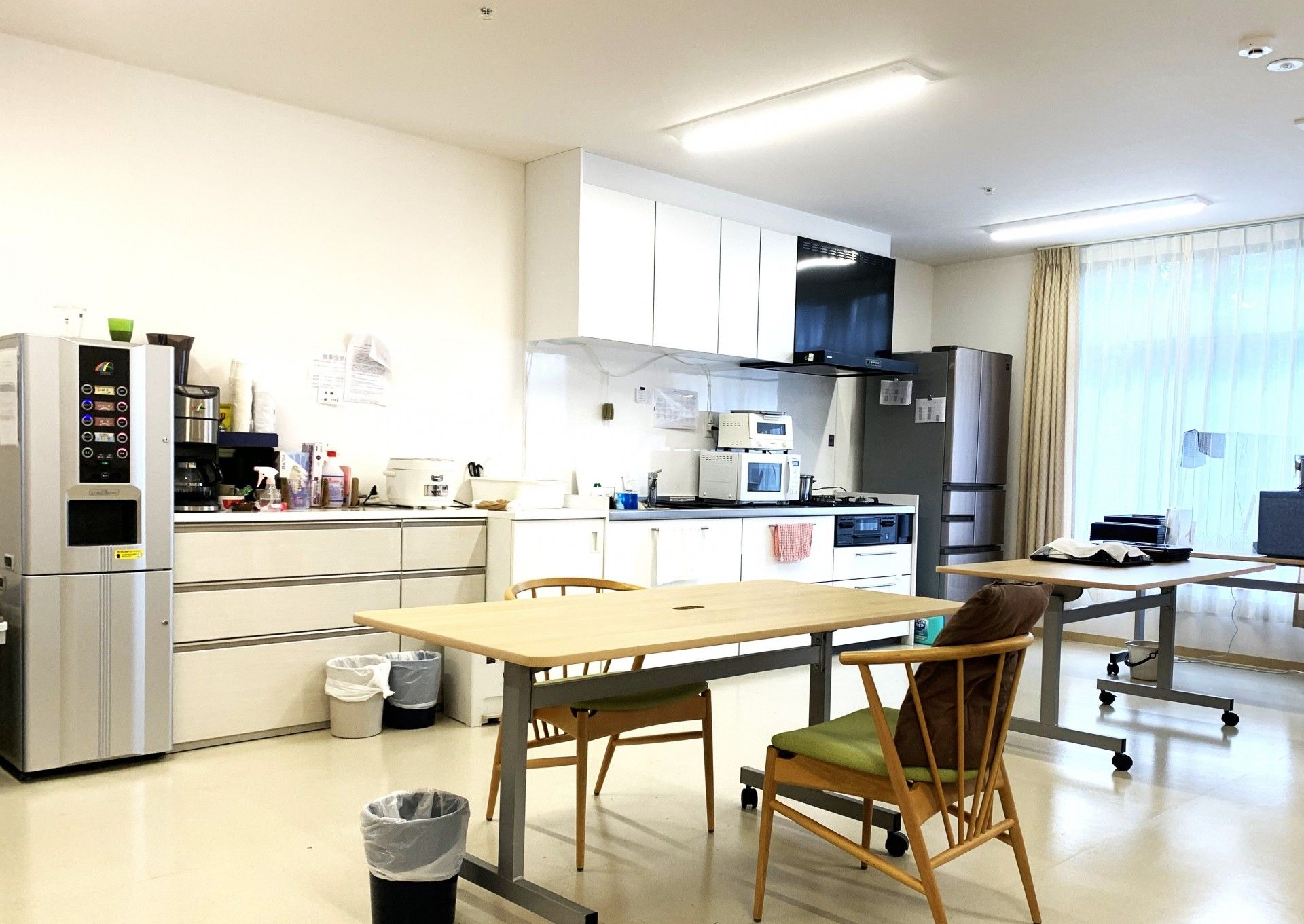 笑顔でフラワーアレンジメントを楽しんでいる高齢男性とサポートするエプロンを付けた女性スタッフ。