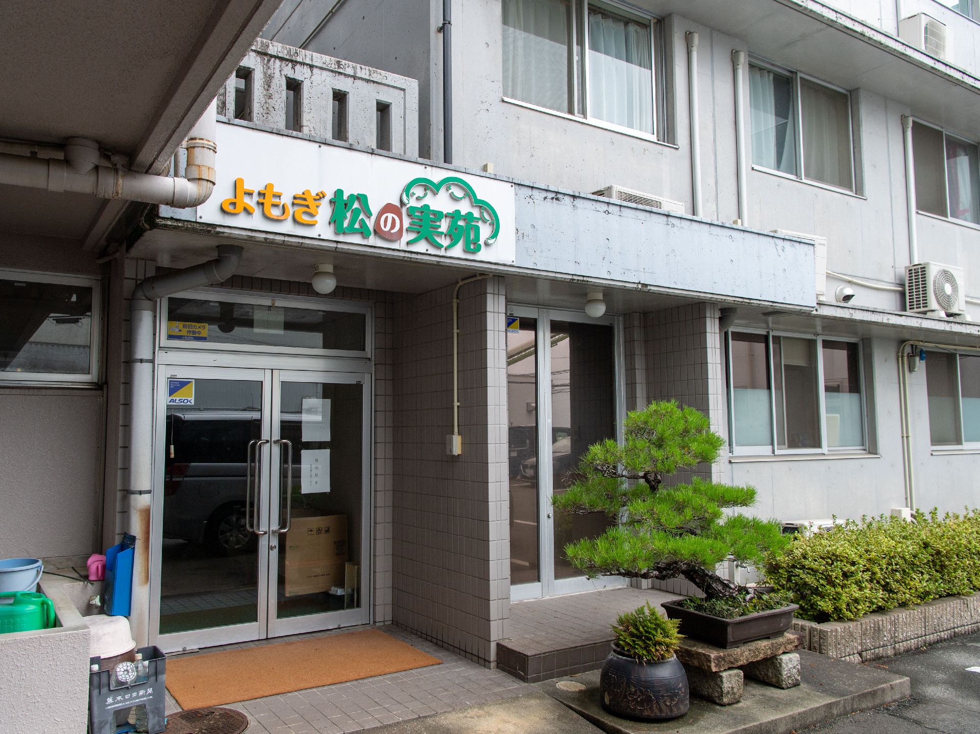 窓ガラスが側面に配置された２階建ての白い外観の建物
