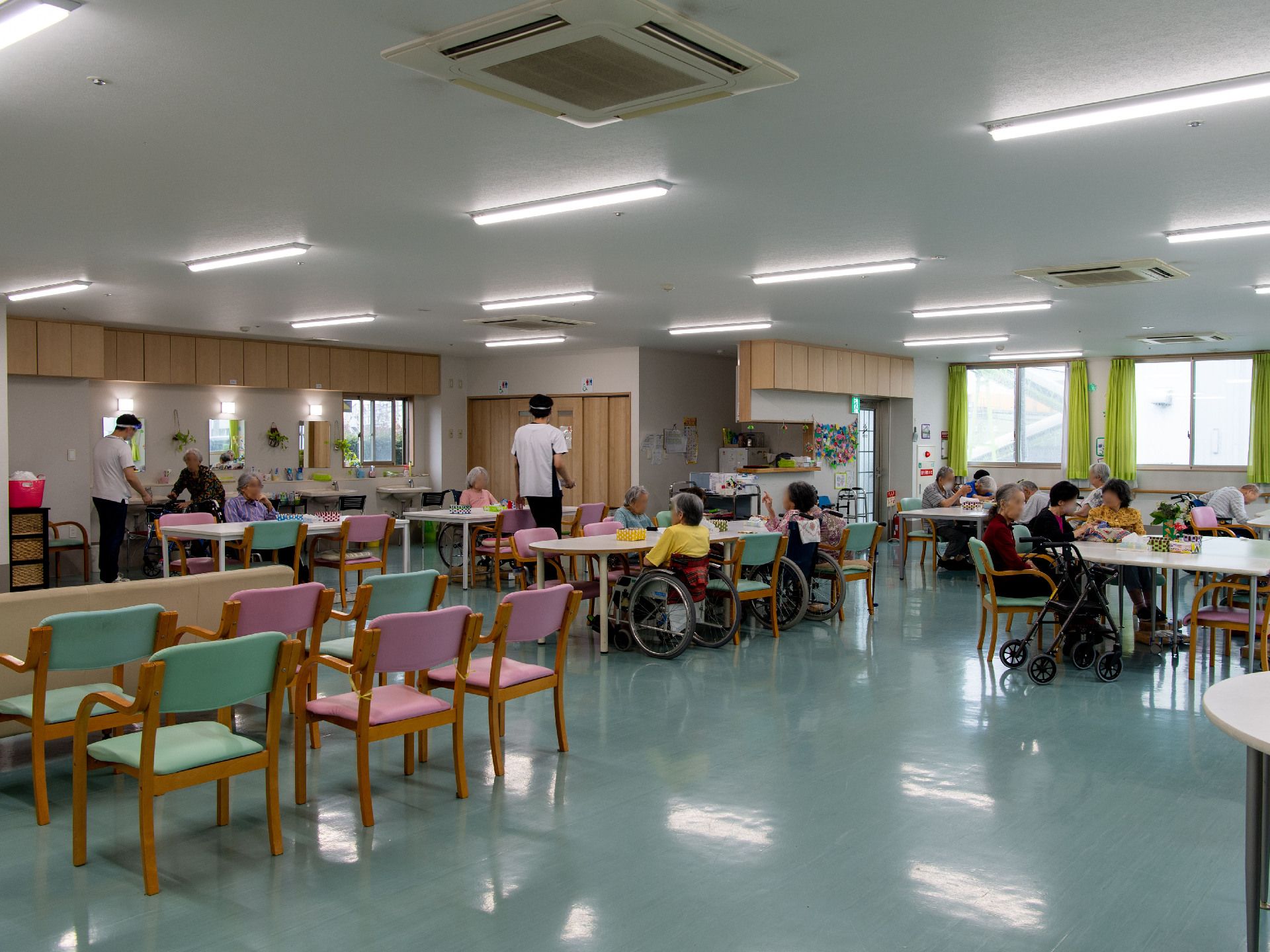机の置かれた広間にある椅子に座る入居者様