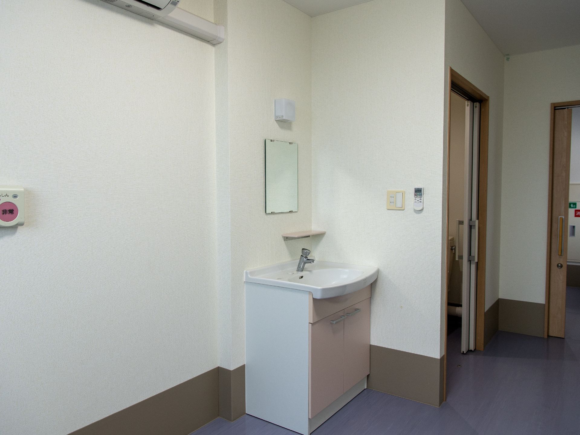 白い壁の一角に設けられた鏡のついた洗面台