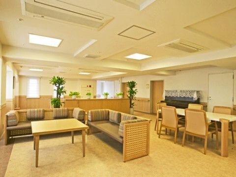 「センチュリーシティ西千葉」の機能訓練室兼多目的ホール「綴」（6F）。足付き性のよいソファーに腰掛けている。