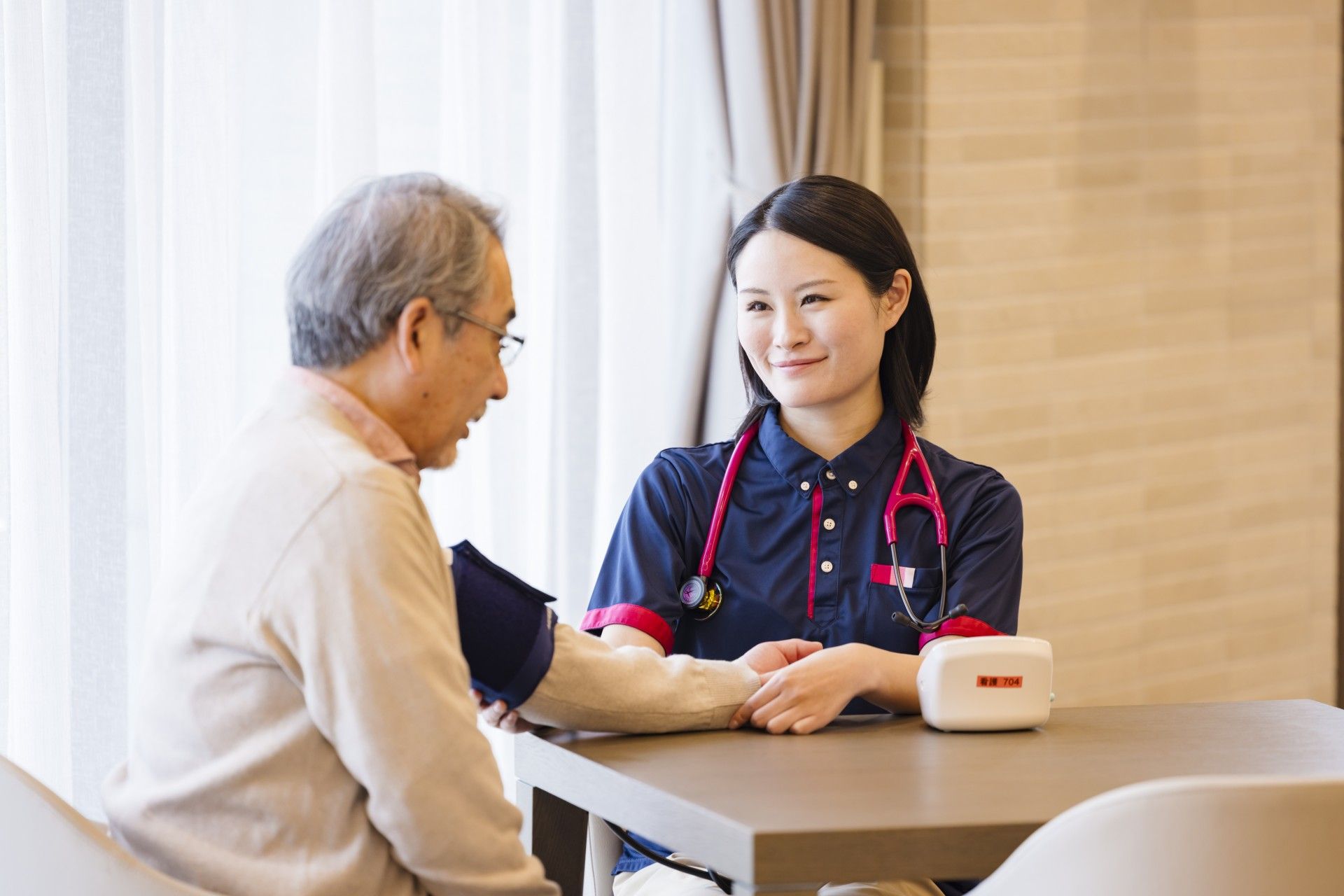 窓際にテーブルとチェアが置かれ、ベッドとチェストが設置された部屋