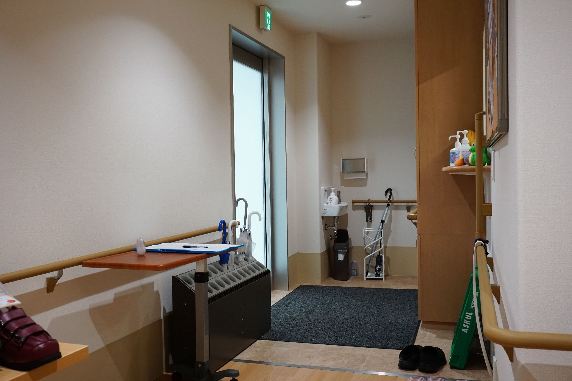 傘立てやマットが配置された非常口